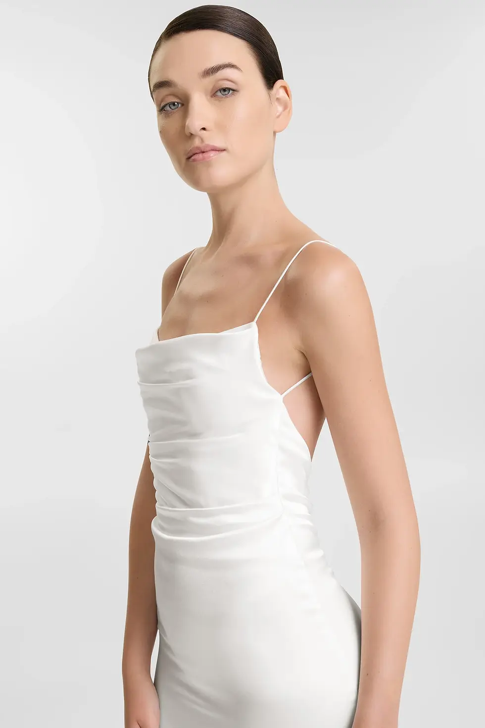 Thumbnail: Woman wearing a white dress, thin straps, posing, and looking at camera.