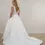 Thumbnail: Woman in elegant white wedding dress with V-back and long train.