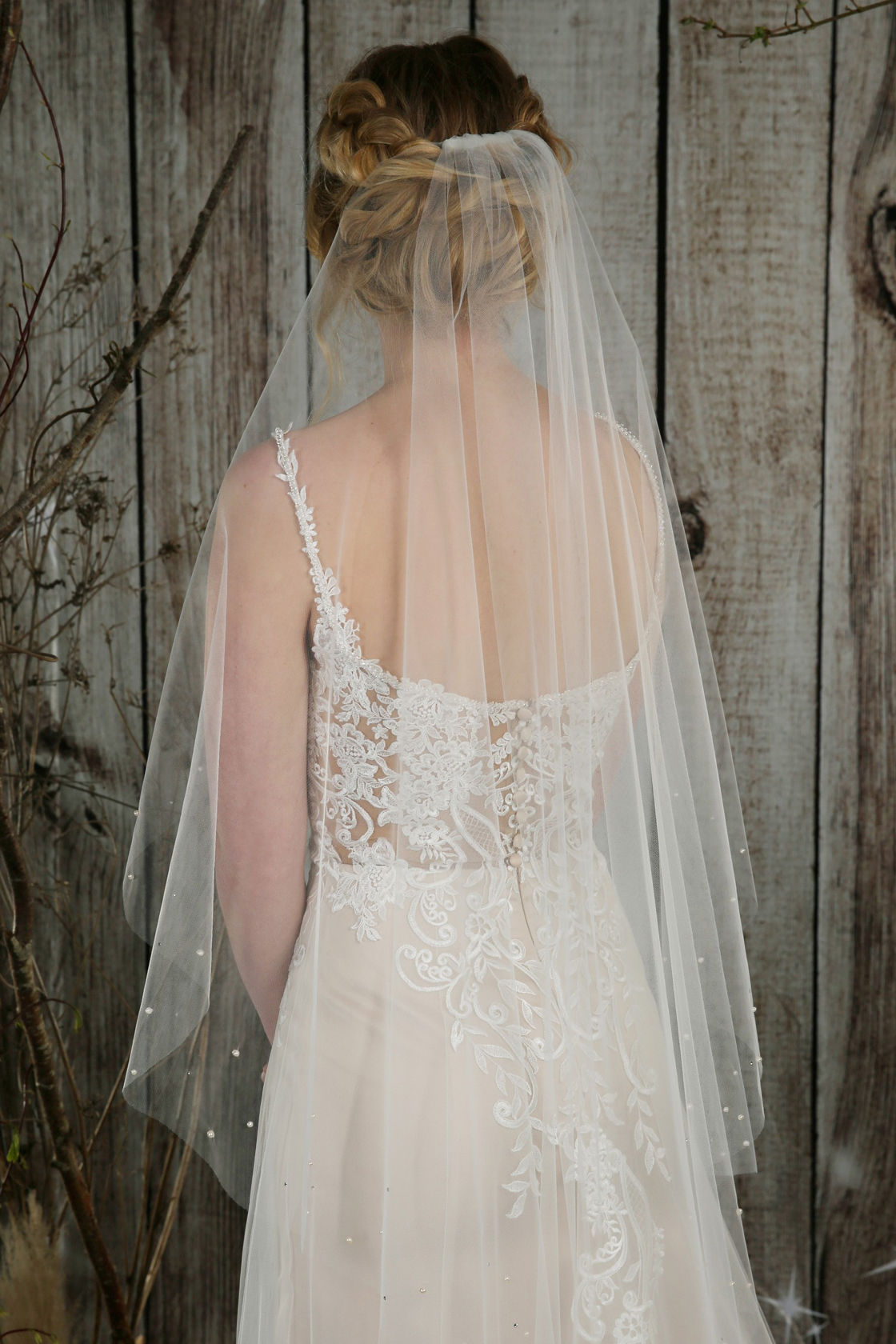 Bride in wedding dress, veil; Lace detail, wooden background; And she loves.