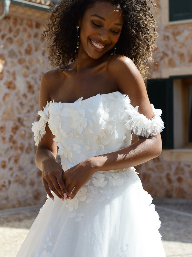 Smiling woman in white floral, off-shoulder wedding dress Alena Leena, Jade.