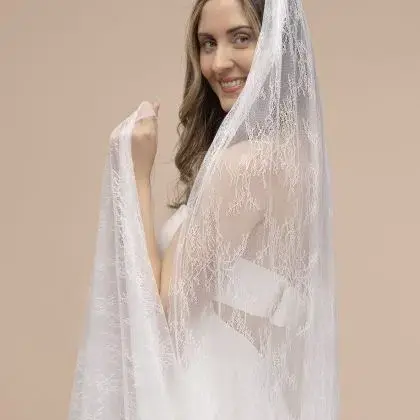 Thumbnail: Smiling woman wears a wedding dress and a Bow Two Tier Veil in front