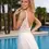 Thumbnail: Smiling woman in white dress, near a pool, looking back. Chosen by Khya, Orelle