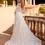Thumbnail: Woman in elegant off-shoulder white lace wedding dress standing on balcony. And She loves bridal boutique in berkshire 