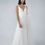 Thumbnail: Woman wearing a white wedding dress with a low neckline and floral detailing.