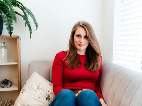 Fifi Sclif sat on a sofa in a red top