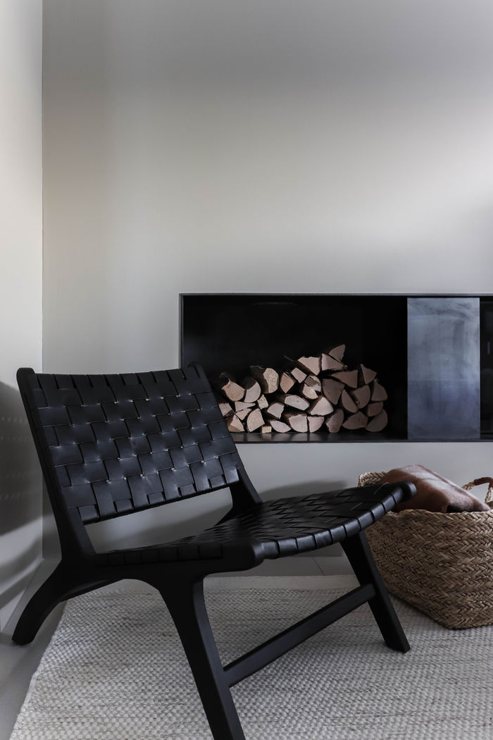 Lounge chair and fireplace detail in open plan living space, Zug Switzerland.