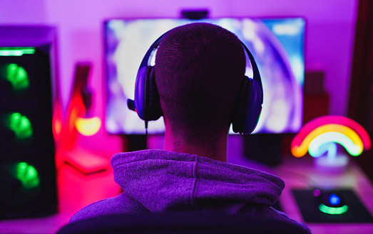 Young man wearing headset and play computer video games online.