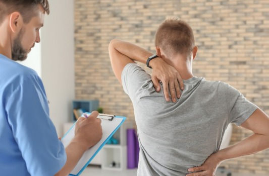 doctor with patient touching his back