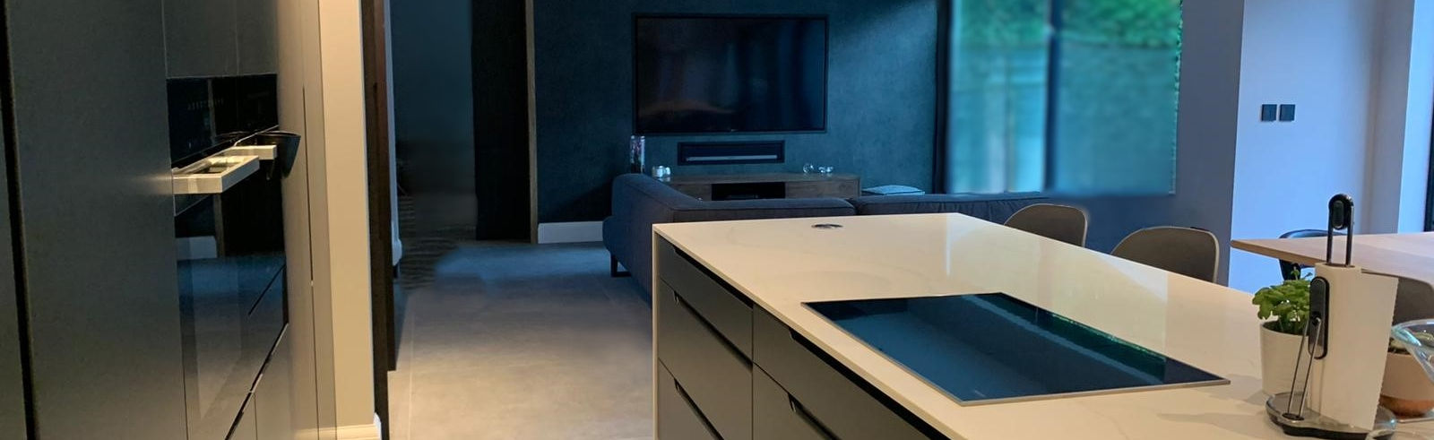 Sleek modern kitchen with handless cabinetry, large island and induction hob in Harpenden