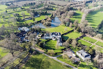 Aerial view of Wavendon village and countryside with period properties, woodland and private lakes