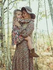beautiful young mother walks with her daughter in the forest. beautiful sunset light, boho
