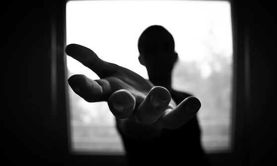 persona che tende la mano in direzione dello schermo, in segno di aiuto nei confronti degli artisti