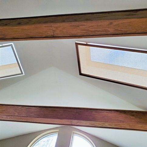 Two SHAADS skylight covers installed between ceiling beams showing white and darker wood frame