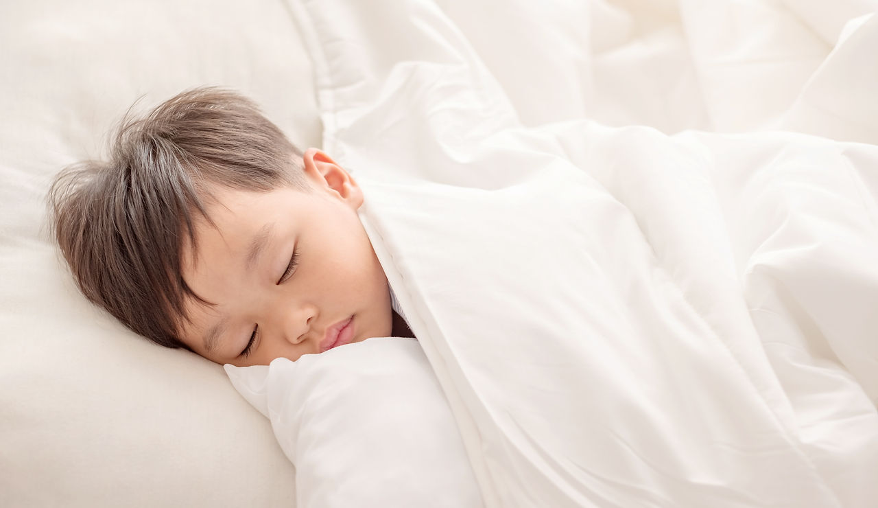 Adorable little boy sleeping in white bed. people, children, rest and comfort concept. Sof