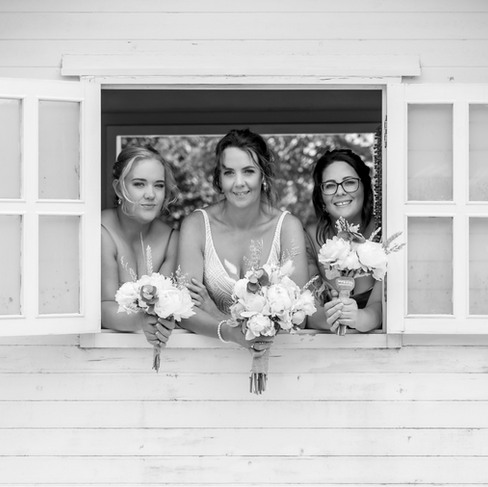 Bride And Bridesmaids Looking Out Of Rustic Country Window