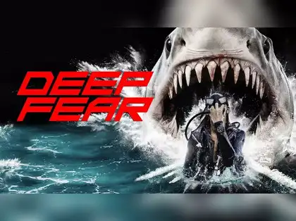 Scuba diver flees from a giant shark in turbulent ocean waves. Red text reads "DEEP FEAR." The scene is intense and dramatic.