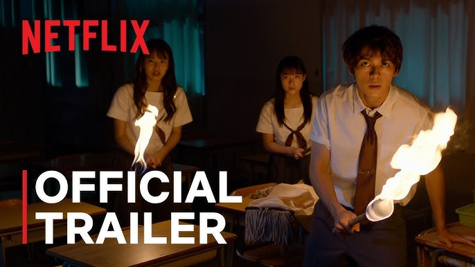 Three people holding flaming torches in a dimly lit classroom, wearing uniforms. The mood is tense. "Netflix Official Trailer" text.