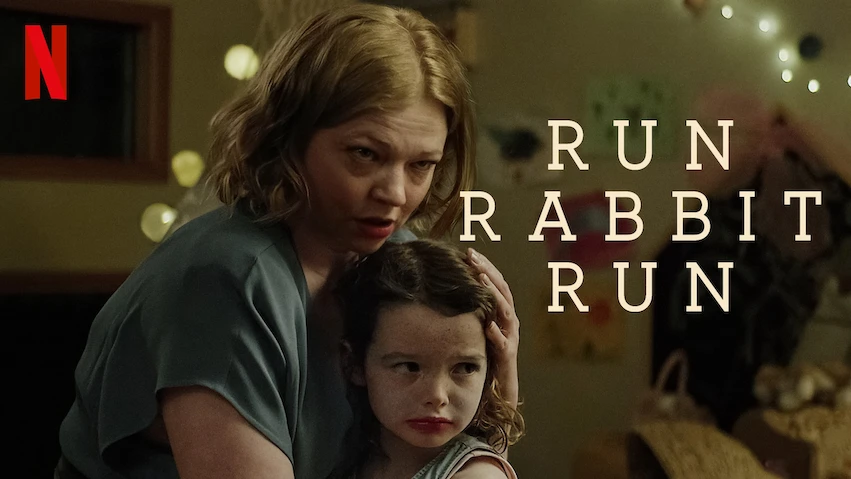 Woman embraces child in a dimly lit room with fairy lights. Text reads "Run Rabbit Run" next to the Netflix logo. Mood is tense and protective.