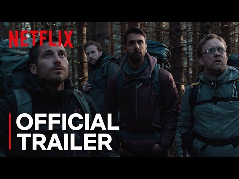 Four men with backpacks stand in a dense, dimly lit forest with serious expressions. Netflix logo and "Official Trailer" text are visible.