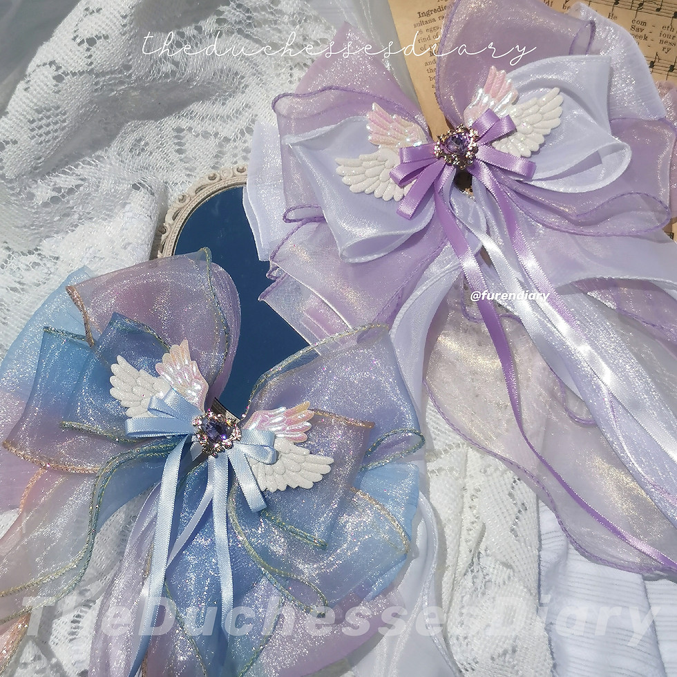 Blue Purple colored ribbons with a heart trinket in the middle layered on top of 4 wings.