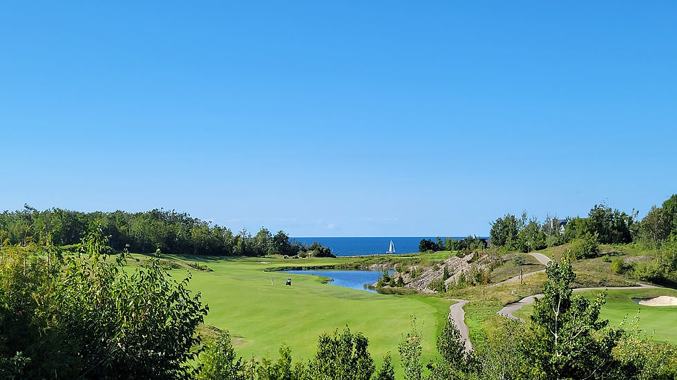 Eye-level view of the 18th green at Bay Harbor Golf Course with sunset over Lake Michigan