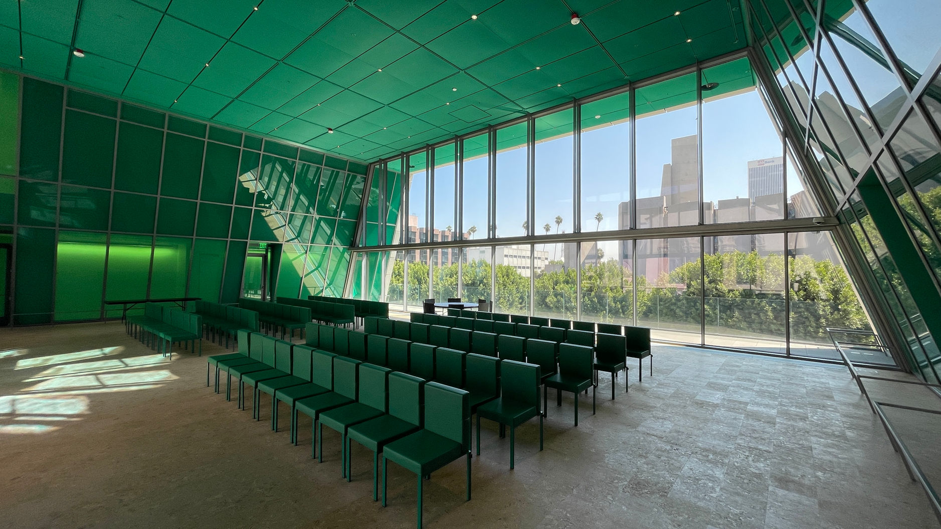 An interior view of a flexible room in the Audrey Irmas Pavilion at the Wilshire Boulevard Temple. The green room is set up with rows of loose seats.