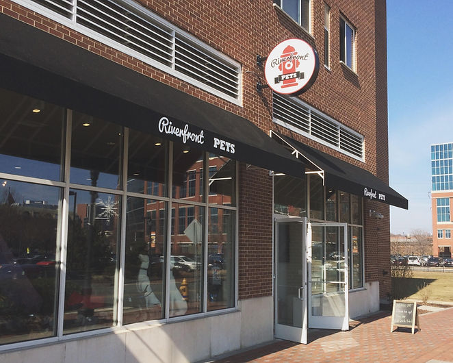Riverfront Pets storefront with red and white sign with fire hydrant logo that says riverfront pets