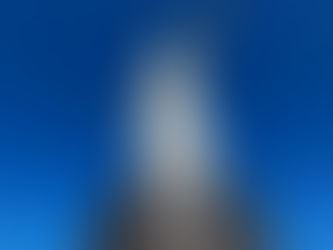 Statue of Christ the Redeemer with outstretched arms against a clear blue sky. Viewed from below, the stone structure is prominent and imposing.