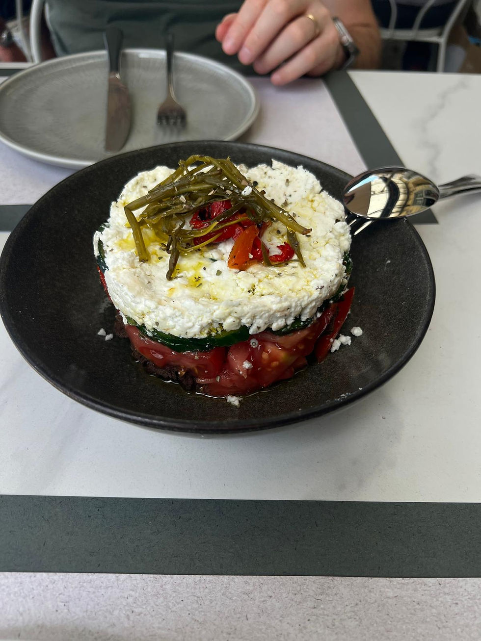 A beautifully structured, modern take on a classic Greek salad layered with fresh cheese and herbs