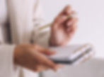 woman entrepreneur with notepad and pen doing a monthly action plan