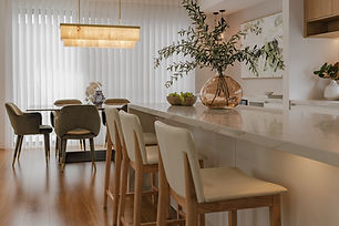 A well-lit dining room that has cozy and comfortable chairs and interior
