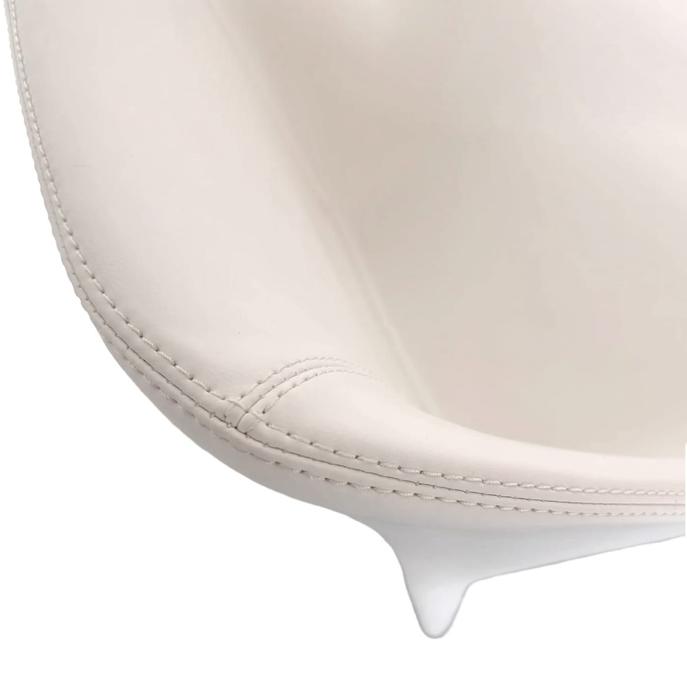 Cream leather chair, detail on the edge, showing stitching and a sleek design.