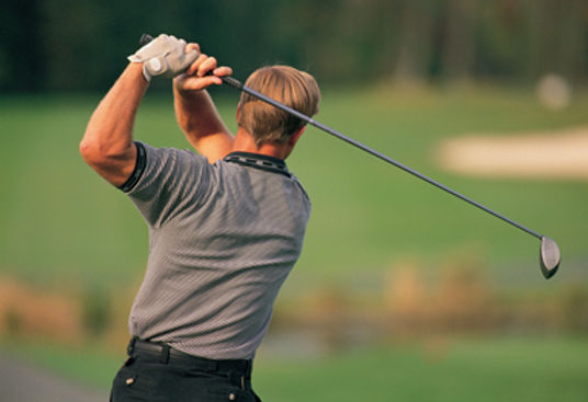 Man swinging golf club - no back pain