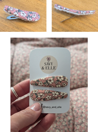 Pink floral hair clips with metal clasps, displayed on a wooden surface. A hand holds a Savy & Elle card with matching clips. Text: @savy_and_elle.