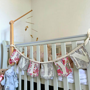 Floarl bunting hanging over the side of a baby's crib