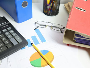 Calculator, charts and binders on a desk used to reconcile VAT returns against a UAE corporate tax return