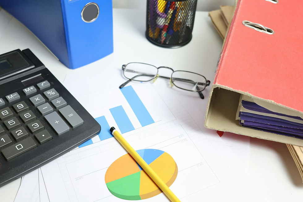 Calculator, charts and binders on a desk used to reconcile VAT returns against a UAE corporate tax return