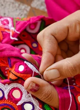 hand of a girl making mirror artwork with needle and thread
