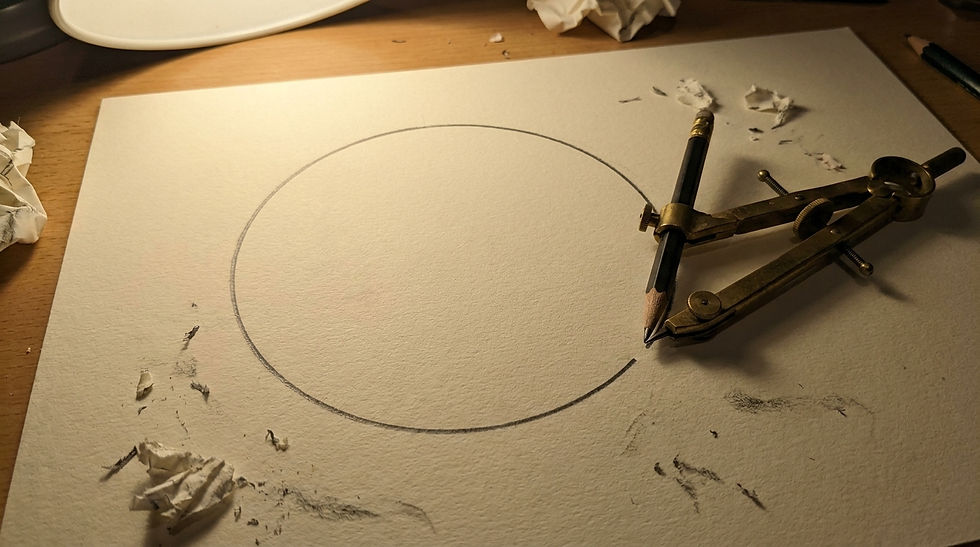 A compass drawing a circle on paper, surrounded by pencil shavings and crumpled paper, on a wooden desk under warm light.