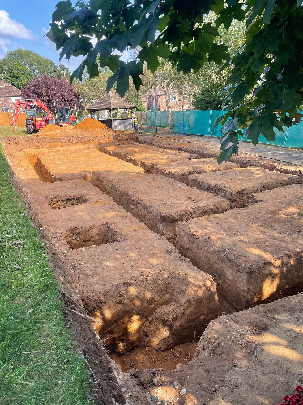 Archaeological excavation trenches cut into orange soil at a dig site