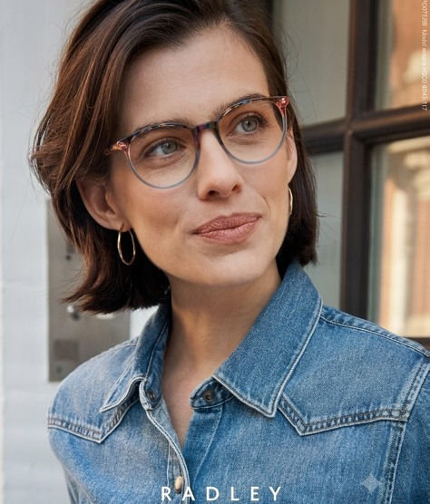 Woman wearing Radley London round eyeglasses and denim jacket outdoors