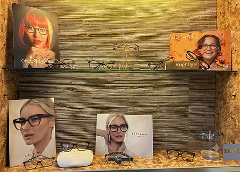 Eyewear display shelf with brand posters and glasses