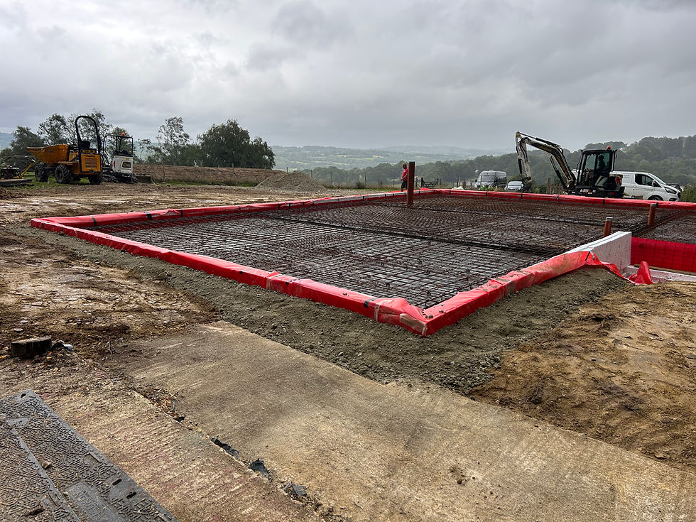 Freshly poured concrete slab with red formwork on a cloudy day