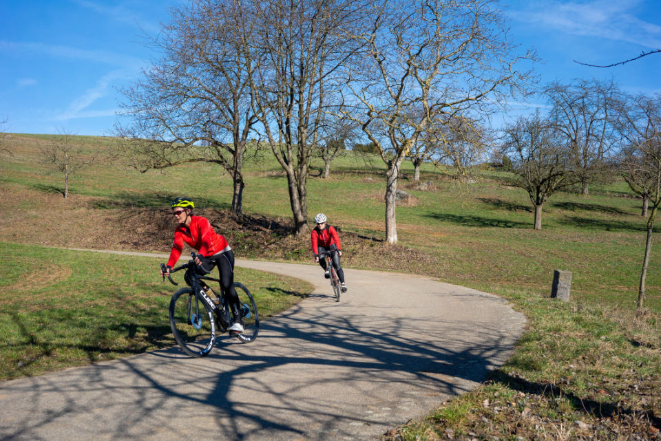 Zwei Rennradfahrer fahren in der Kurve eine Bergstraße hinunter – steht für Vertrauen, Fokus und mentale Stärke im Sportmentaltraining.