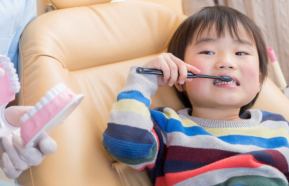 A child shows off how to brush their teeth during an exam.
