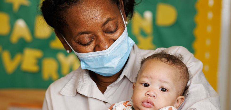A teacher holds a baby.