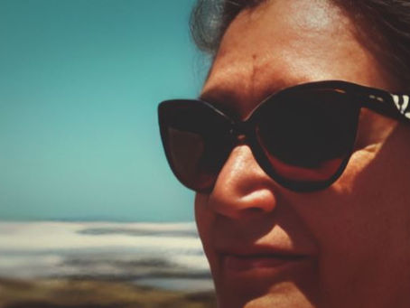 mulher de óculos escuros na praia