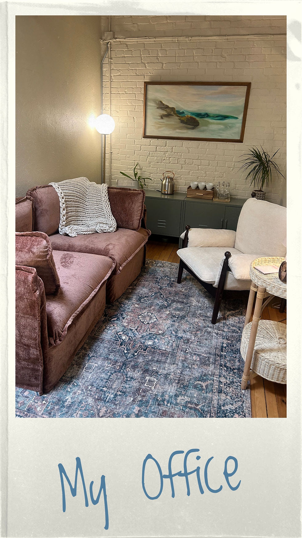 The Flying Sparrow office. The office features a pink couch, white chair, and blue rug. Near the back wall is a lamp, some plants, cabinets, and a seascape painting hung on the wall.