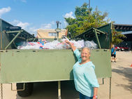 Woman putting bag of school supplies in truck