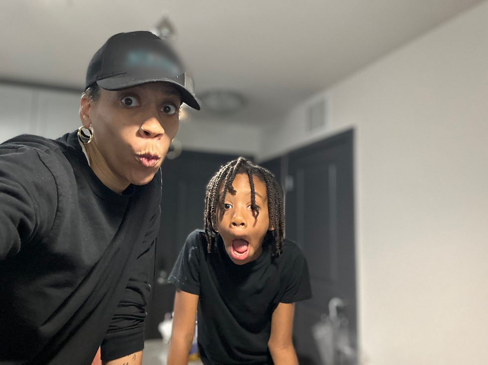 Mother and son in black shirts make surprised faces in a room with white walls and dark doors, creating a playful and shocked mood.